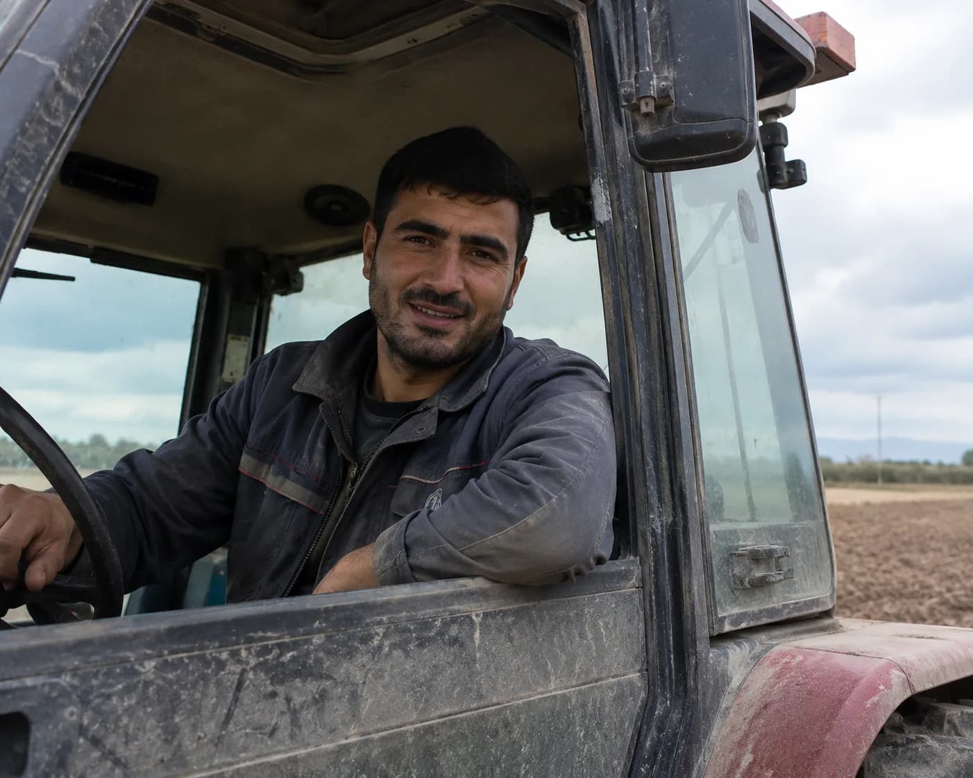 Kabinədən gülümsəyən traktor operatoru